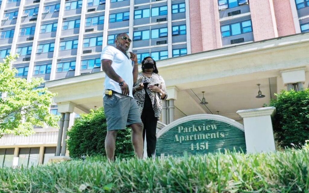 Alana Green and contractor walking infront of entrance to Parkview Apartments in St. Louis, MO.